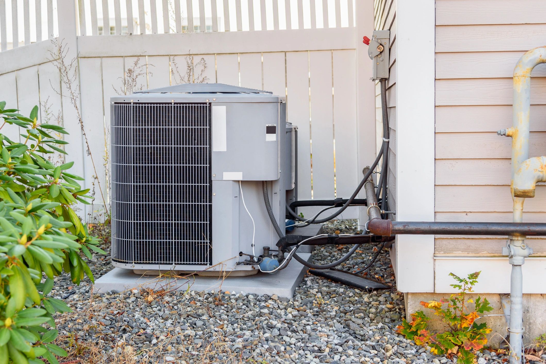 Outdoor air conditioning unit installed beside a house.